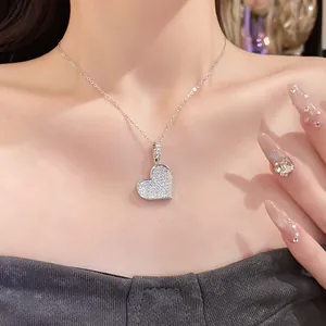Detail shot of an elegant sparkling heart-shaped zircon pendant necklace worn by a model