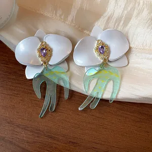 Vue détaillée des boucles d'oreilles en argent avec fleur en résine et hirondelle