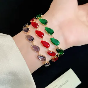 Detailed view of vibrant teardrop zircon bracelets in purple, red, and green on wrist.