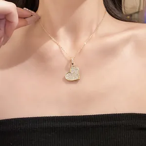 Elegant gold-plated heart pendant necklace with sparkling zircons worn on model