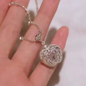Detailed view of an intricate silver-toned heart pendant featuring a sparkling zircon.