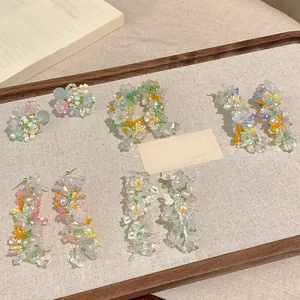 Detailed view of handmade Monet's Garden style beaded flower fringe earrings and studs