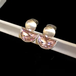 Detailed view of vintage pink half-moon crystal ear clips with brushed silver finish.