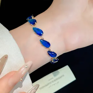 Detailed view of elegant gold bracelet featuring sparkling blue waterdrop zircons