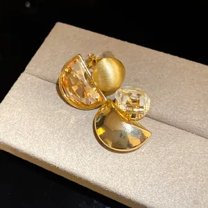Detailed view of vintage gold clip-on earrings featuring semi-circular crystal pendants