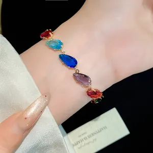 Detailed close-up view of a vibrant teardrop-shaped zircon bracelet on a woman's wrist
