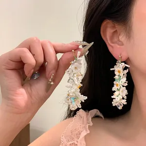 Intricate detail of handmade Monet garden style floral beaded long fringe earrings for women