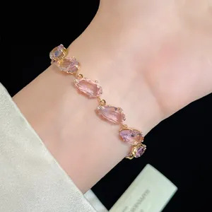 Detailed view of an elegant gold bracelet featuring sparkling pink teardrop-cut zirconia stones