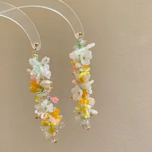 Close-up macro detail of handmade Monet garden style colorful flower beaded long tassel earrings.
