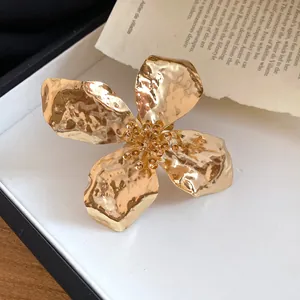 Close-up of elegant gold metal flower bracelet featuring unique wrinkled petal texture