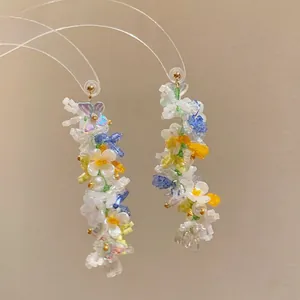 Detailed view of handmade floral beaded earrings with delicate butterfly accents