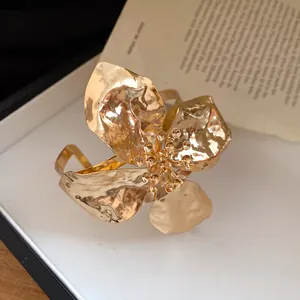 Detailed view of the gold hammered flower texture on this open cuff bracelet