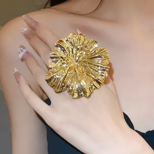 Detailed view of a large gold pleated flower ring showcasing the metallic texture