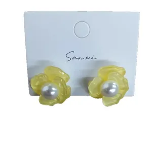 Fresh yellow flower stud earrings with pearl center on white display card