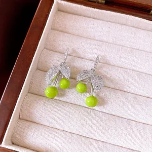 Fresh green cherry drop earrings with sparkling zircon leaves presented in a jewelry box