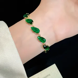 Detailed view of a gold-plated bracelet featuring vibrant green pear-cut cubic zirconia.
