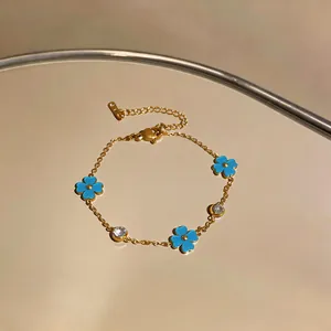 Detalle de cerca de una pulsera de acero inoxidable con flores azules y circonitas