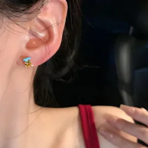 Exquisite asymmetric zircon stud earring with yellow gemstone and blue accent detail