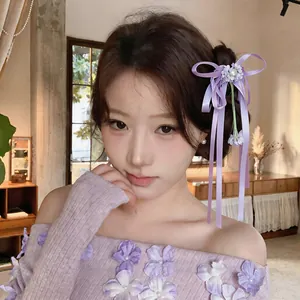 Détail de l'élégante pince à cheveux en ruban violet de style français avec perle et fleurs