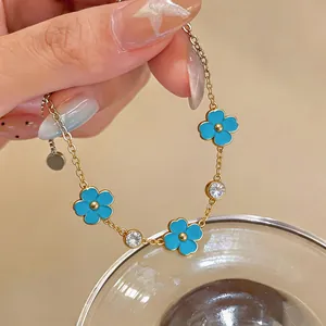Detalle de primer plano de una pulsera de acero inoxidable con flores azules y circonitas