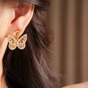 Close-up view of elegant gold-plated butterfly clip-on earrings with shimmering zircons