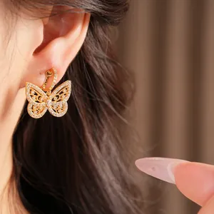 Detail of an 18K gold-plated butterfly clip-on earring paved with shimmering zircons.