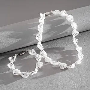 Detailansicht einer eleganten weißen Perlenkette mit gedrehtem Design und Perlen