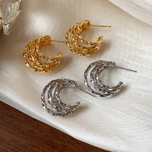 Detailed close-up showing gold and silver 18k plated textured C-shaped hoop earrings