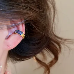 Close-up view of an elegant 18k gold plated ear cuff featuring blue square zircons