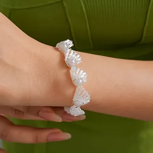 Detailansicht eines handgefertigten Armbands aus weißen Glasperlen am Handgelenk.