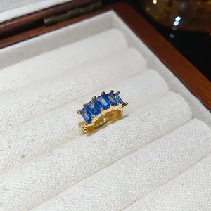 Detail view of square blue zircon ear cuff with 18k gold plating in jewelry box