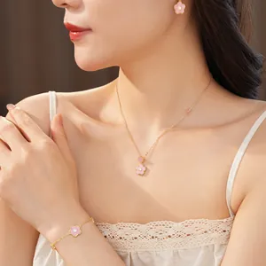 Modell trägt ein elegantes rosa Blumenschmuckset inklusive Halskette und Armband
