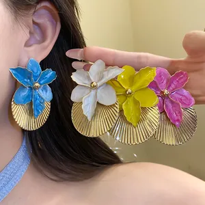 Vibrant enamel flower earrings with pleated golden texture for a stylish vacation look.