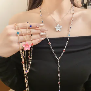 Detail showing colorful crystal beaded necklaces with pink and white flower pendants