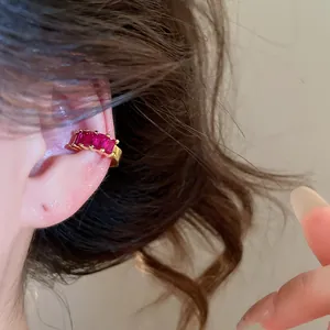 Detail of 18k gold plated ear cuff with square pink zircon stones worn on the ear