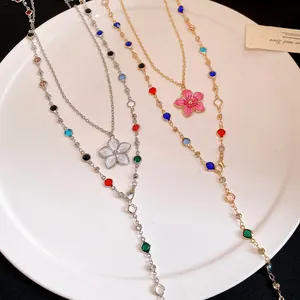 Close-up view of colorful crystal bead necklaces with flower pendants on a white plate