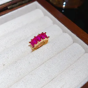 Close-up of 18k gold plated ear cuff with square red zircons in luxury jewelry box