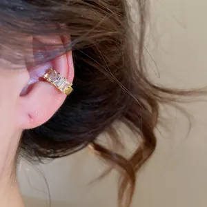 Detailed view of 18k gold plated ear cuff with square zircons worn on model's ear