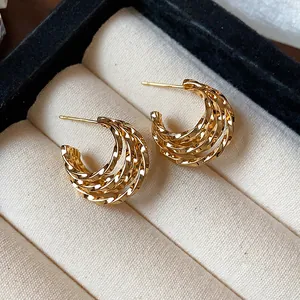 Close-up of elegant 18k gold plated C-shaped multi-layer twisted hoop earrings