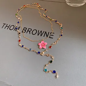 Detailed view of a vintage gold-tone necklace with colorful crystal beads and pink flower.