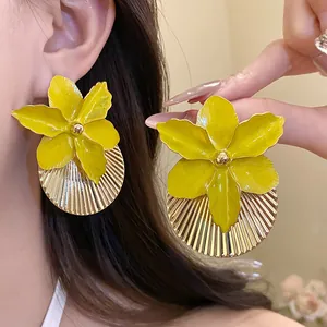 Close-up of elegant yellow oil-drop flower earrings with a unique gold pleated texture