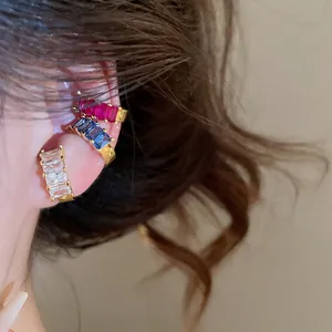Detailed macro view of elegant 18k gold plated square zircon ear cuffs on model's ear