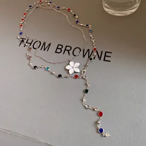 Close-up detail of vintage style crystal beaded necklace featuring white flower pendant
