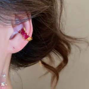 Close-up view of a gold-plated ear cuff featuring four elegant rectangular red zircons