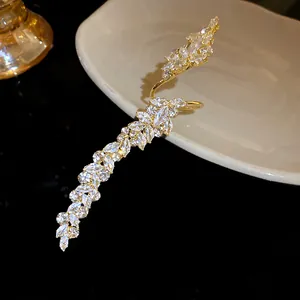 Close-up of a gold-toned open ring featuring marquise-cut zircon stones in a leaf design