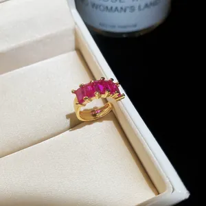 Close-up of 18k gold plated ring with rectangular pink zircon stones in a jewelry box.