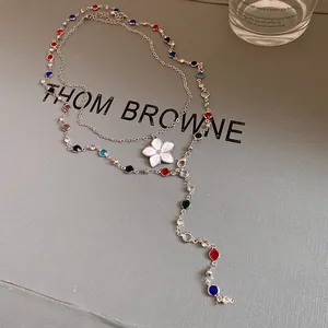 Vintage palace style beaded necklace with white flower pendant and colorful crystals detail.