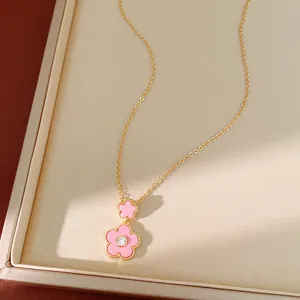Nahaufnahme einer eleganten Halskette mit rosa Emaille-Blumenanhänger und Goldbeschichtung