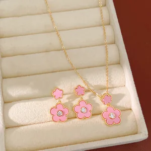 Detail von Halskette und Ohrringen mit rosa Blumen, Goldbeschichtung und Zirkonia