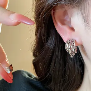 Minimalist 18k gold plated silver needle C-shaped textured hoop earrings worn on model ear